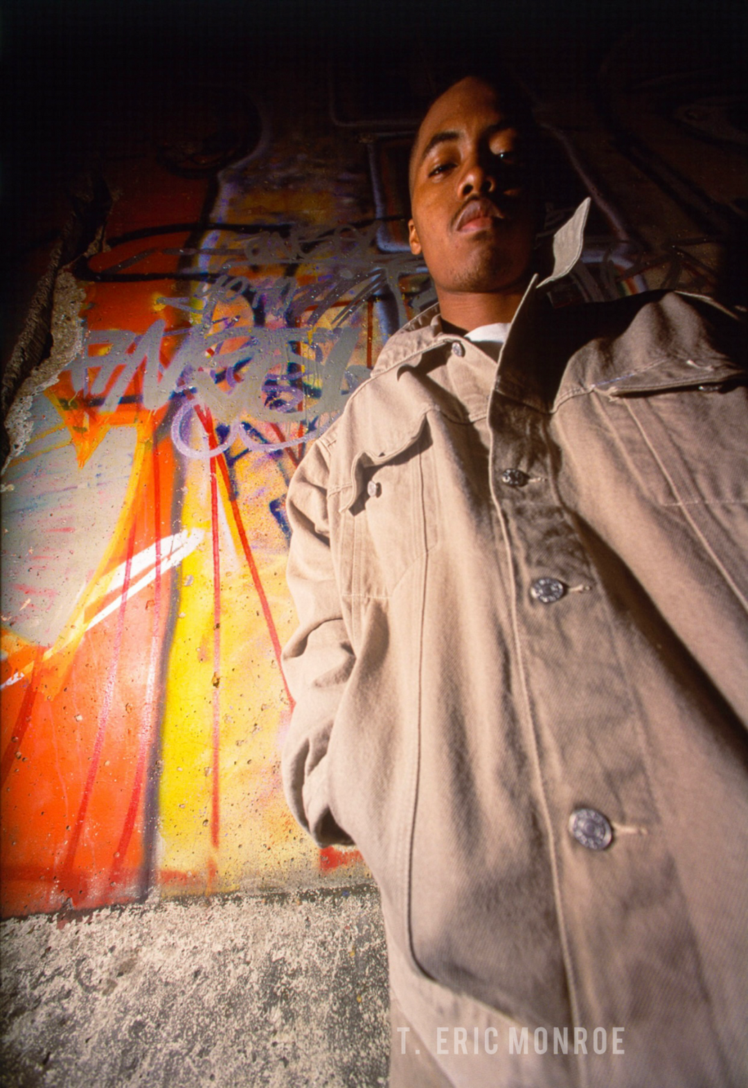 Nas in front of a section of the Berlin Wall on display in NYC, 1994